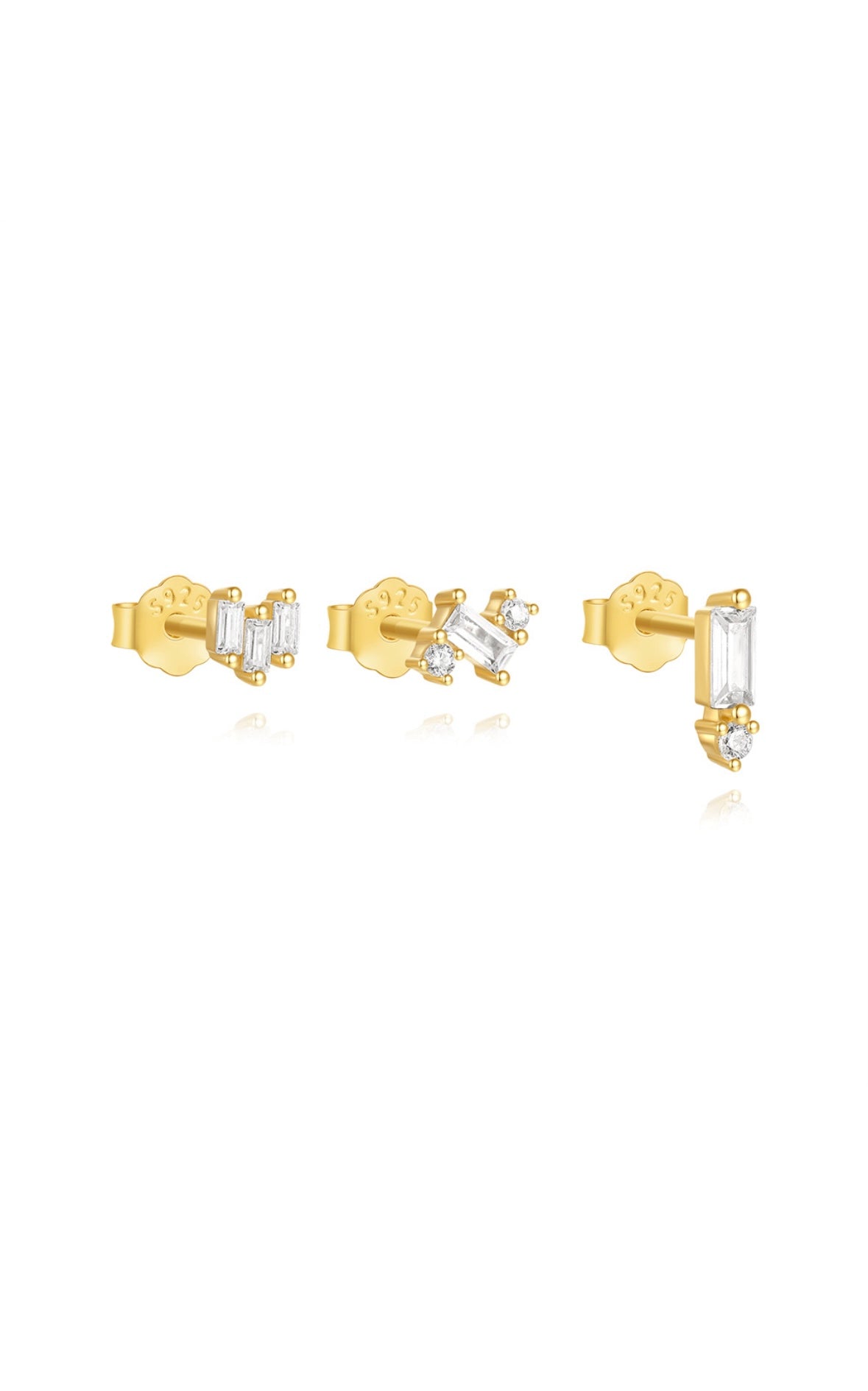 Three pairs of gold post earrings earrings, each with clear gems, sit on a white background.