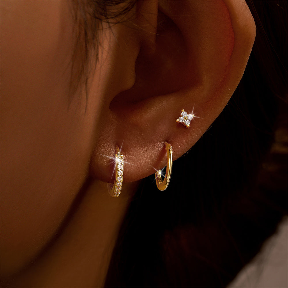 Close-up of an ear with three earrings from the Trio Set: Floral Stud Set Gold.