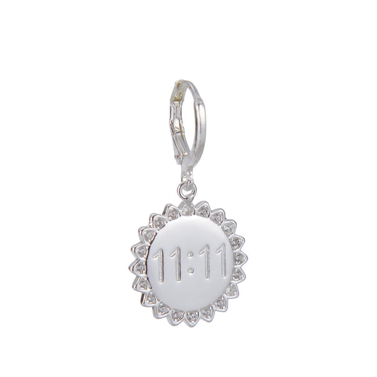 Silver charm earring with a circular pendant engraved with "11:11" and surrounded by small gems.