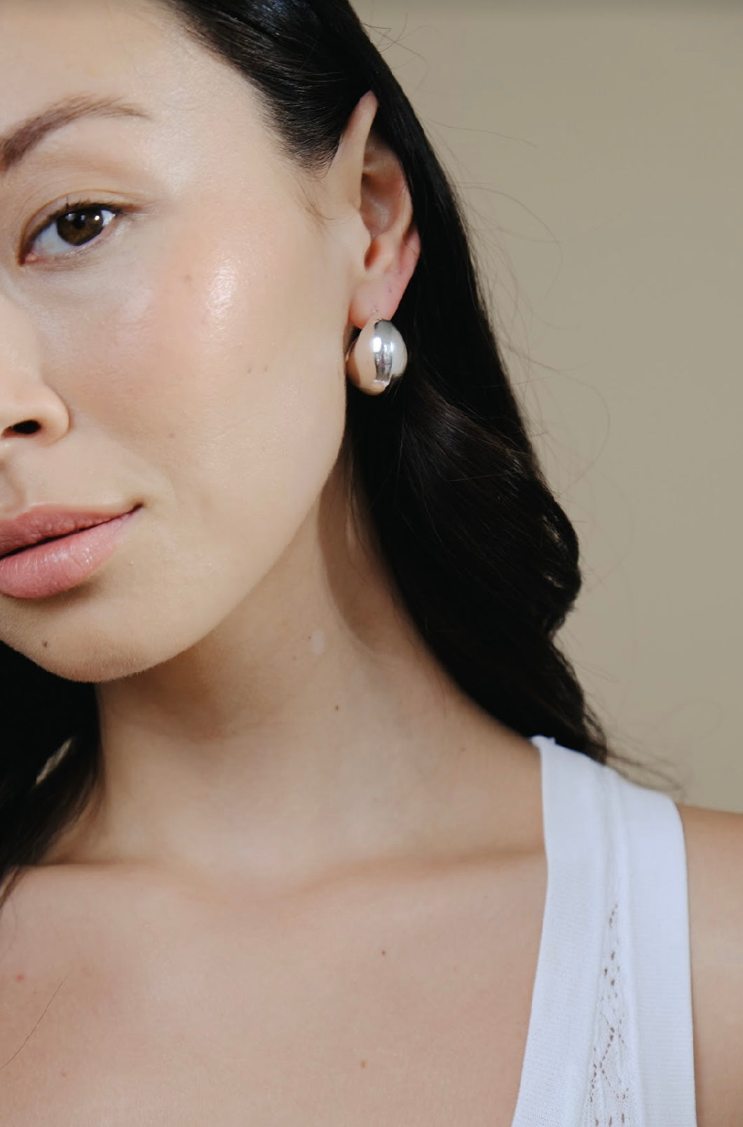 Close-up of a woman with dark hair wearing a Silver Twilight Moon Hoops earring.