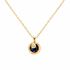 Diamond and blue gemstone pendant on a white background