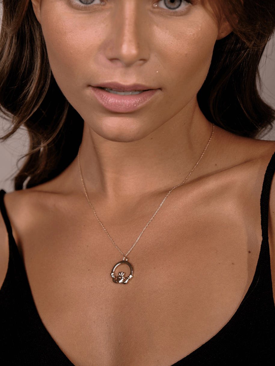 Close-up of a woman wearing a Silver Claddagh Necklace.