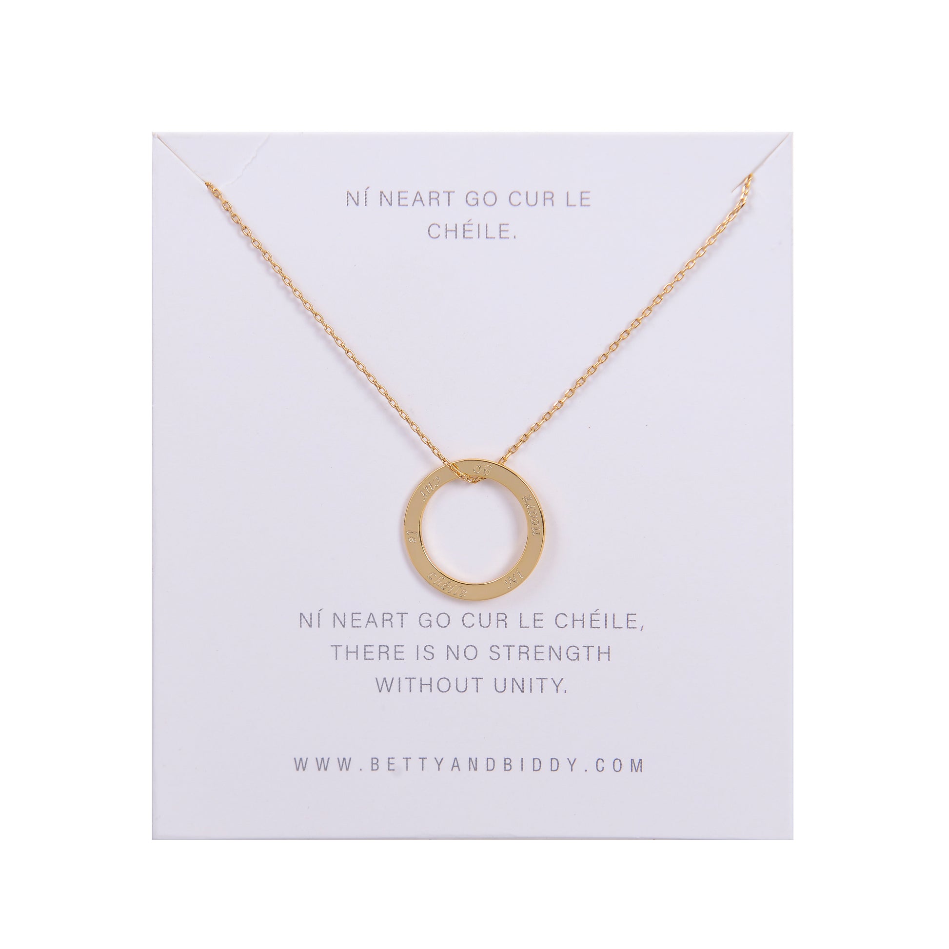 A gold Ní neart go cur le chéile necklace with a circular pendant rests on a white card with text.