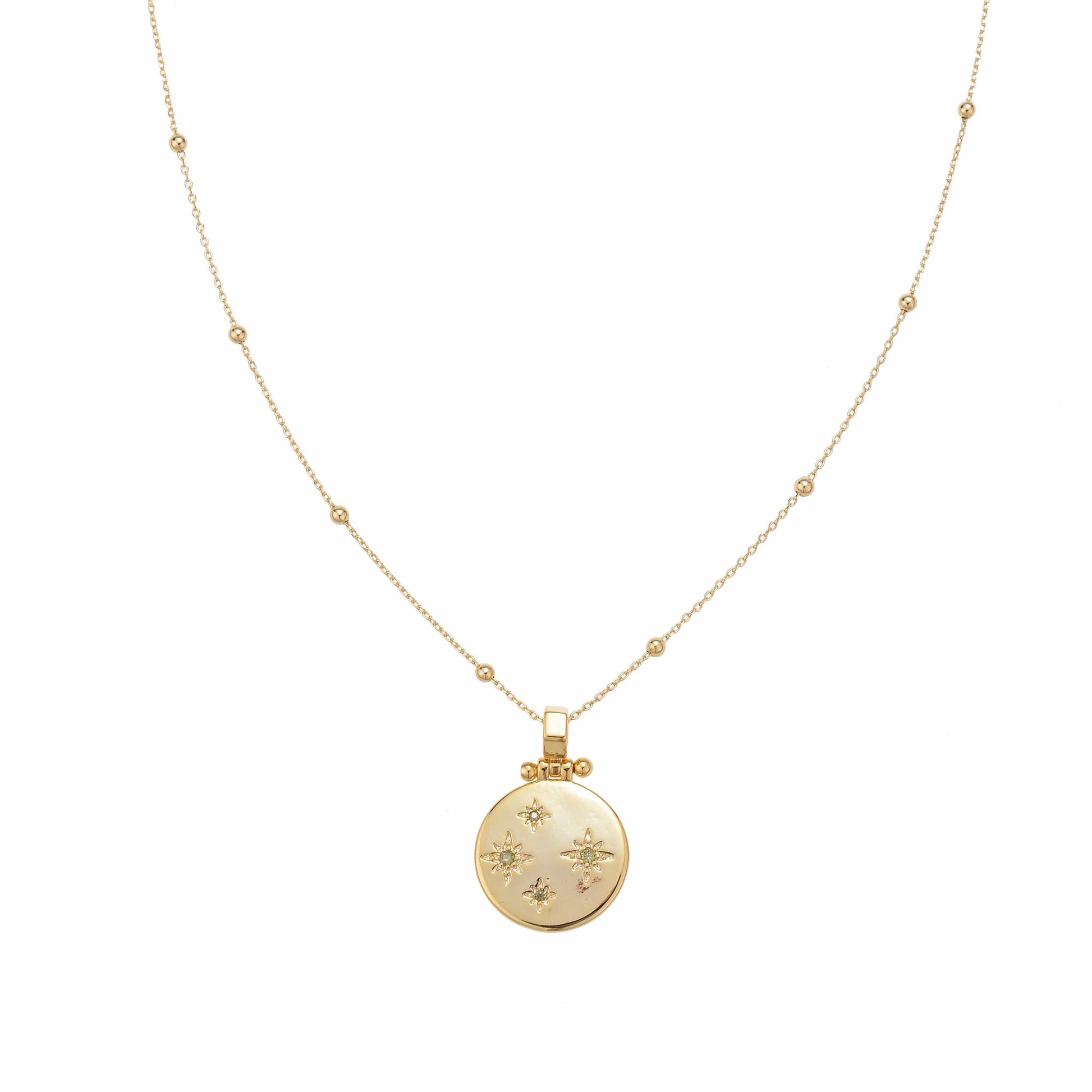 Gold delicate necklace with a round pendant featuring star motifs.