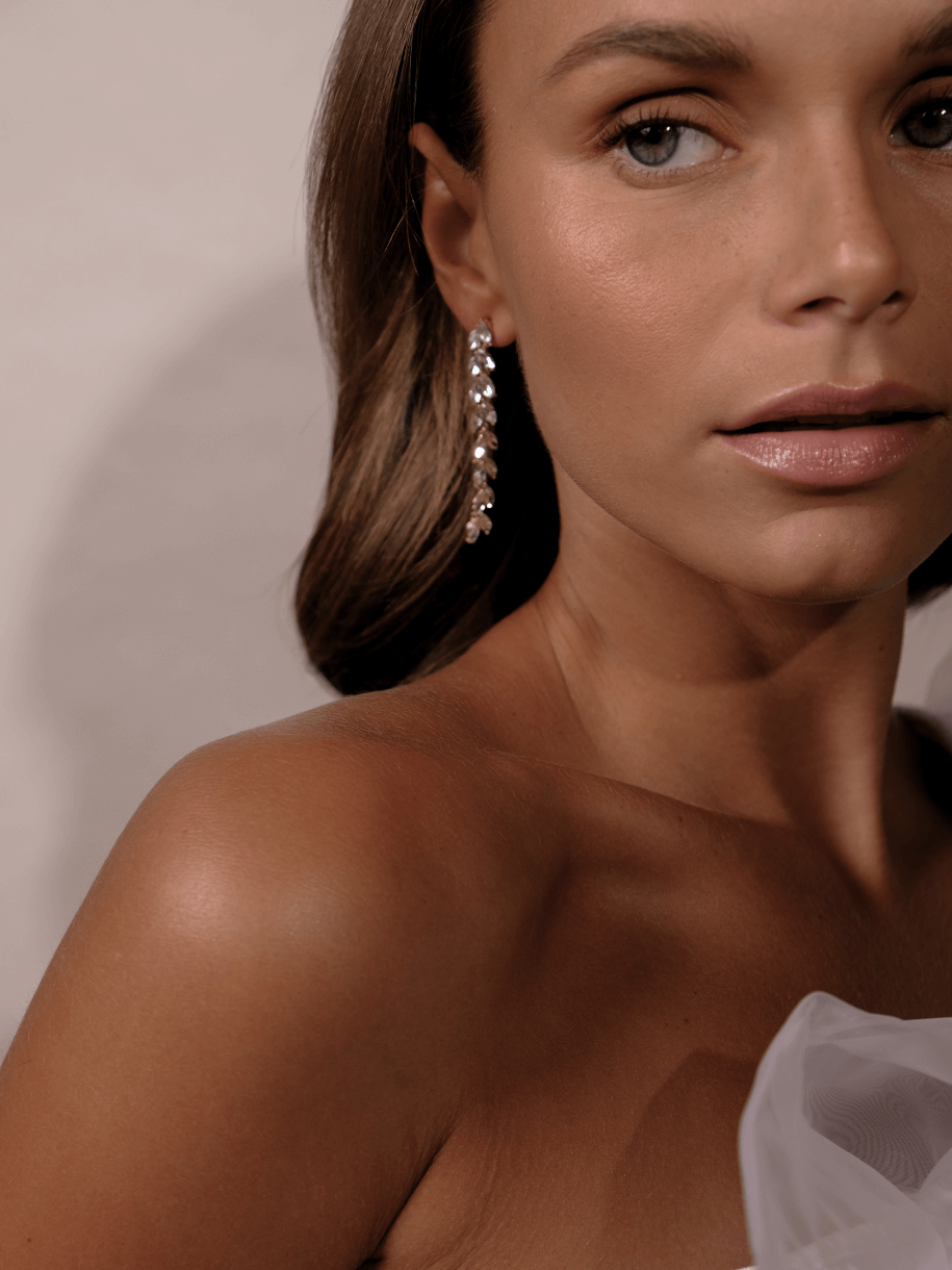 Close-up of a woman wearing Bridal Crystal Leaf Earrings.