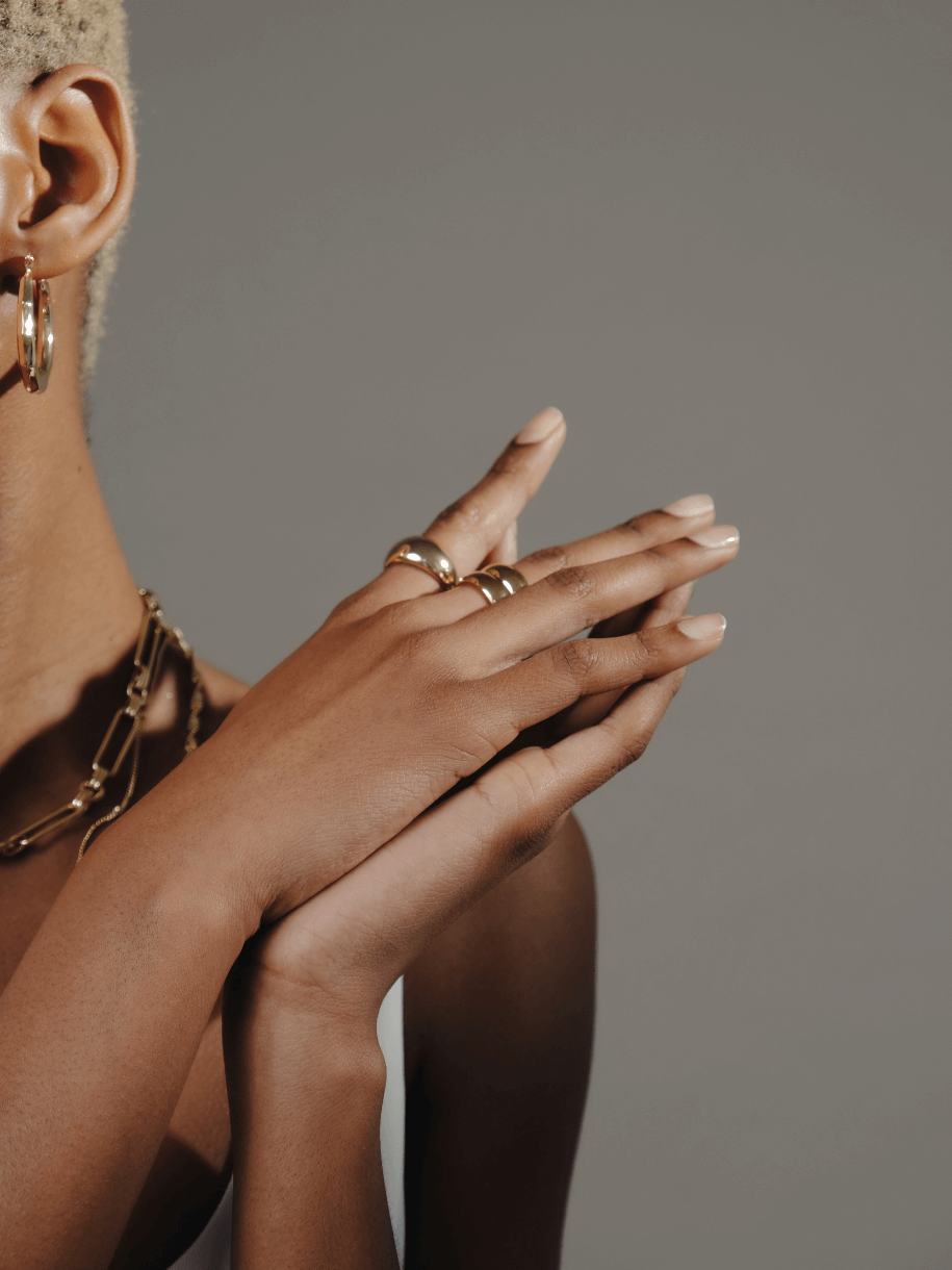 Close-up of a person with gold Dome Ring.