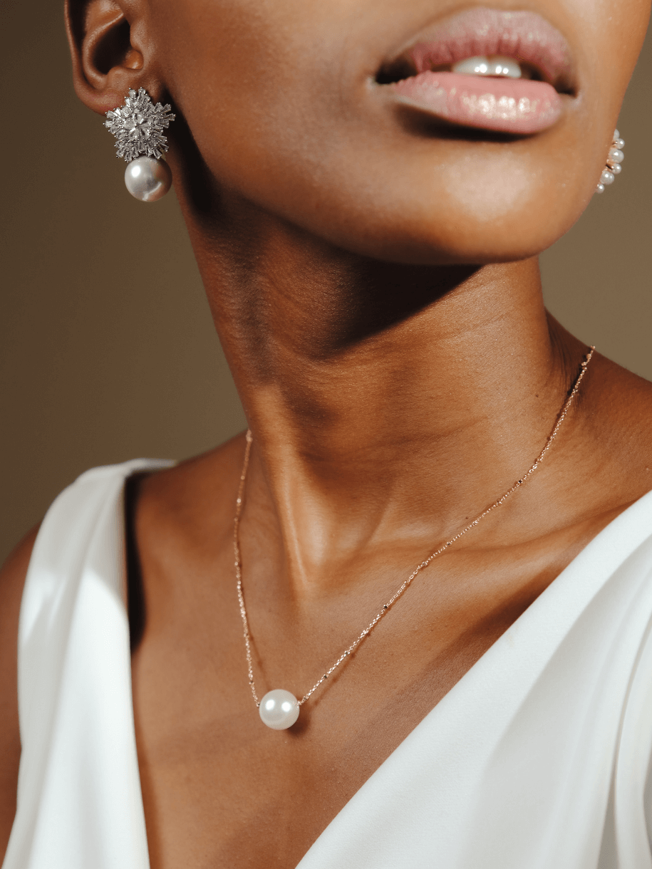 Close-up of a woman wearing a Bridal Single Pearl Necklace.