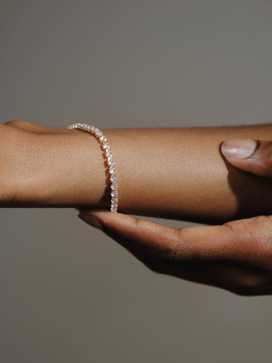 Close-up of a person's arm with a Tennis Bracelet Clear diamond bracelet being held by another person.
