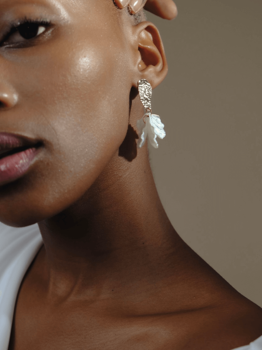 Close-up of a person with dark skin wearing a Bridal Lumi Earring.