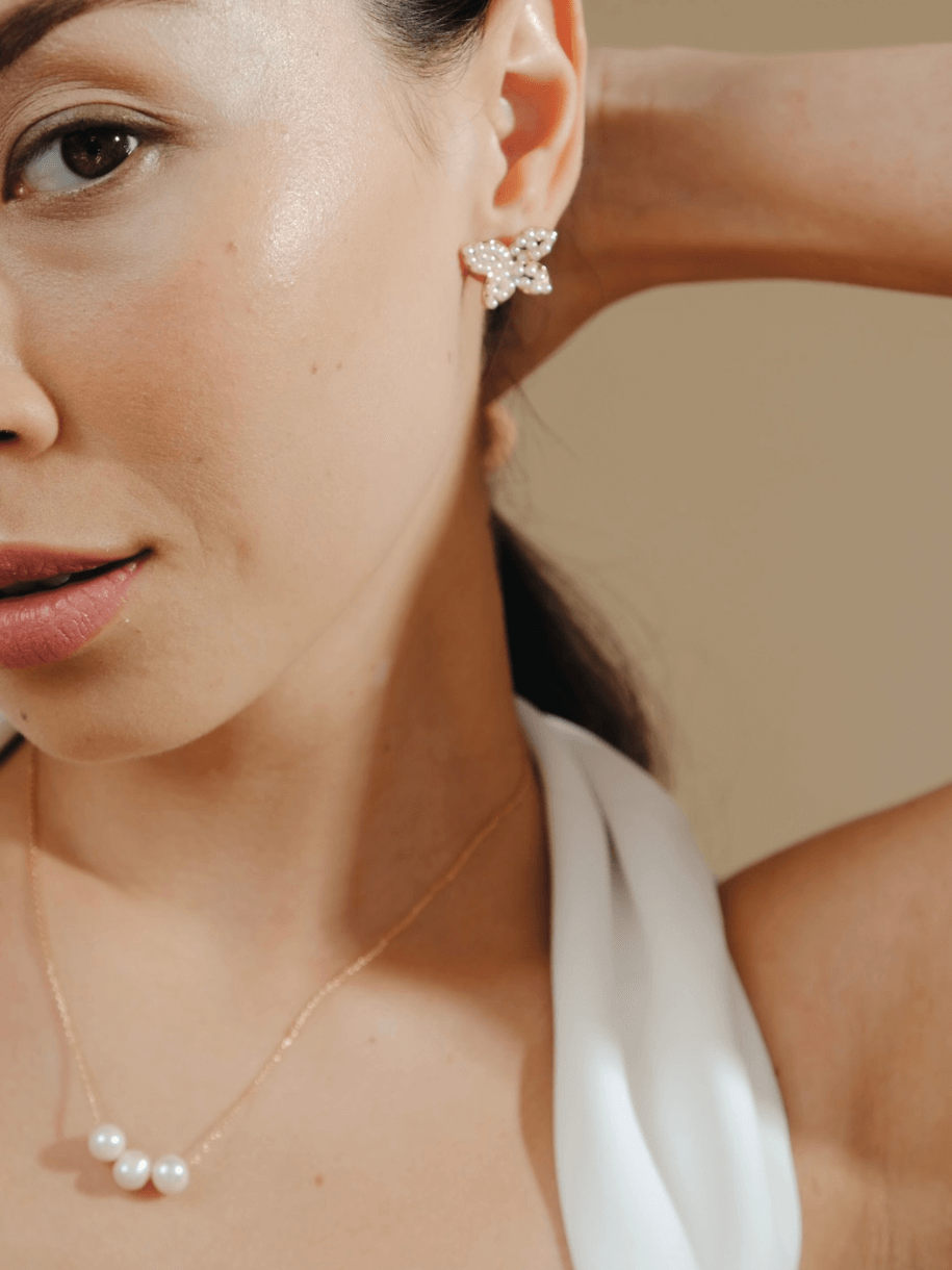 Close-up of a woman wearing a Bridal Three Times a Charm Pearl Necklace.