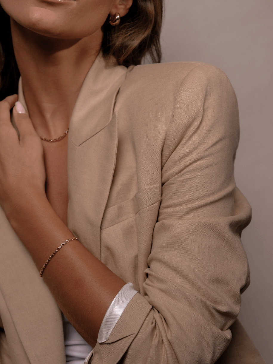 A person wearing a tan blazer with a Wafer Bracelet.