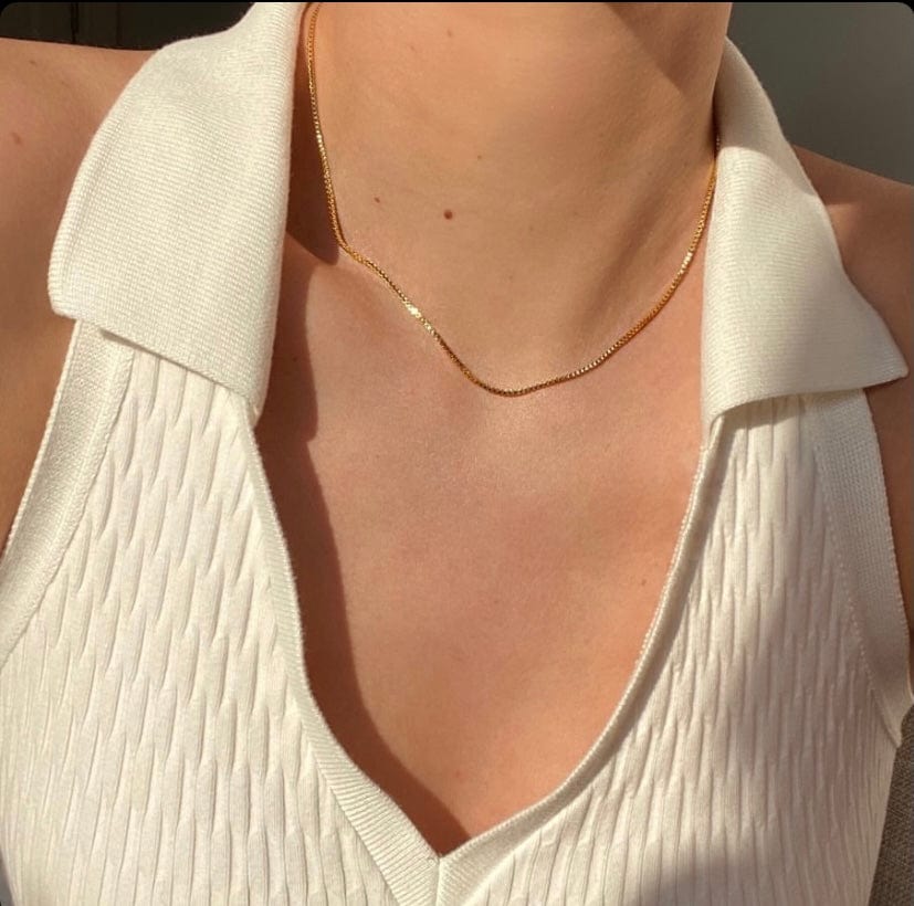 A person wearing a Box Chain 14 inches with a white textured shirt with a gold chain.