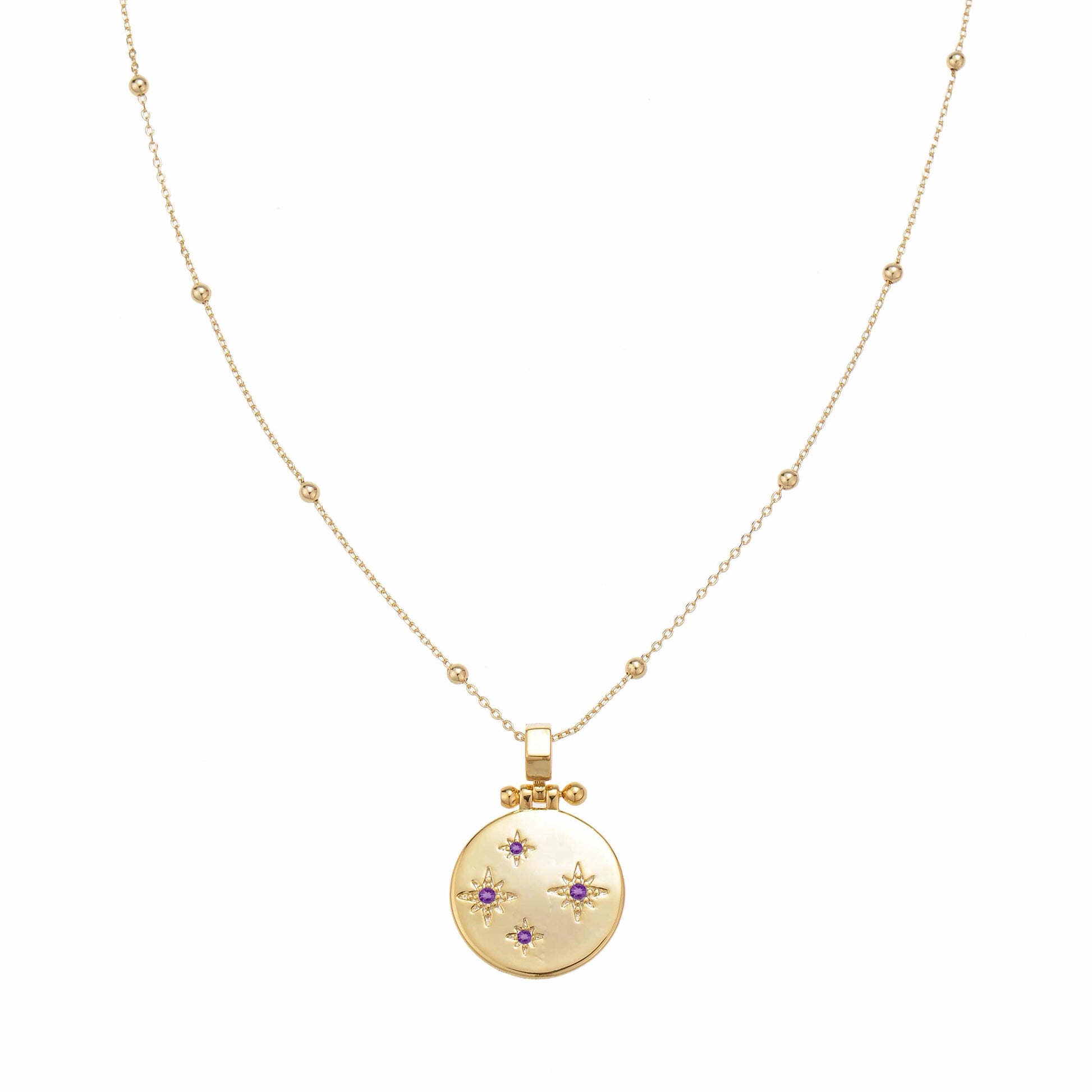 Gold delicate necklace chain with a round pendant decorated with starbursts and purple gems.