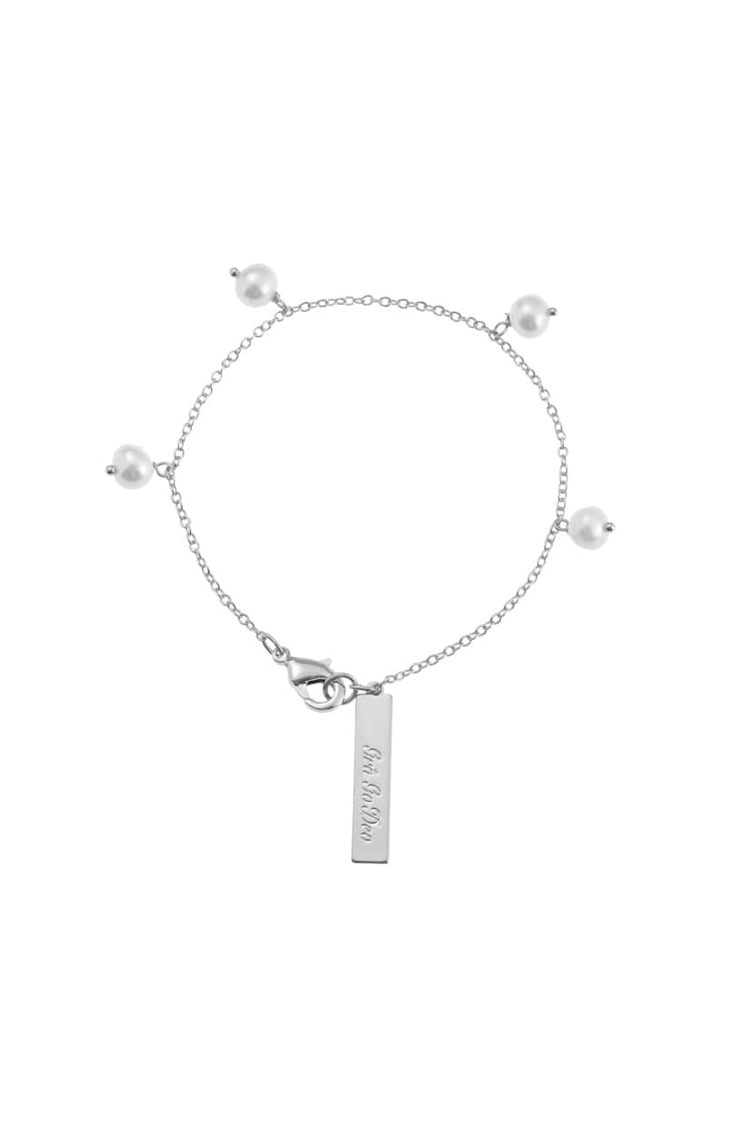 A delicate silver bracelet with pearl accents and a branded tag is displayed on a white background.