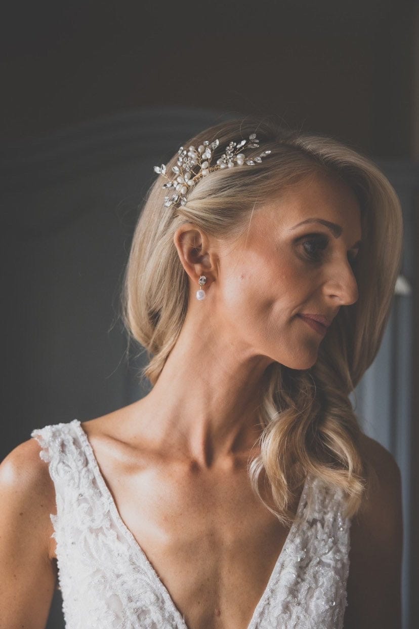 A woman with blonde hair, wearing a Bridal Snow Drop Pearl beaded dress and jewelry.