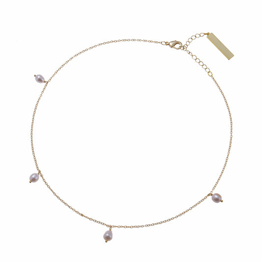 A snow drop pearl necklace on a delicate gold chain bracelet