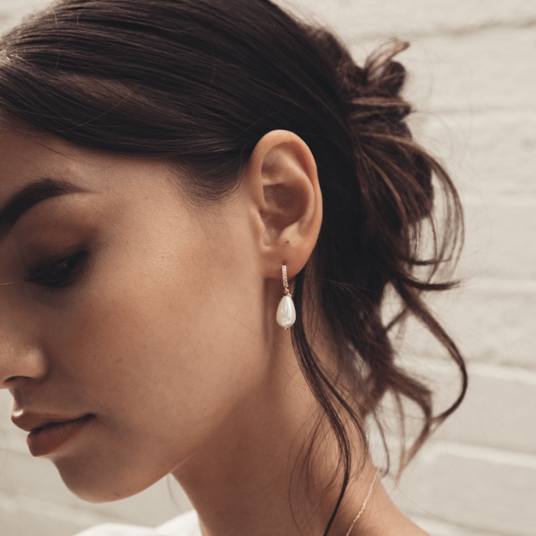 Profile of a woman wearing a Bridal Diamante Pearl Drop Gold Huggie earring.