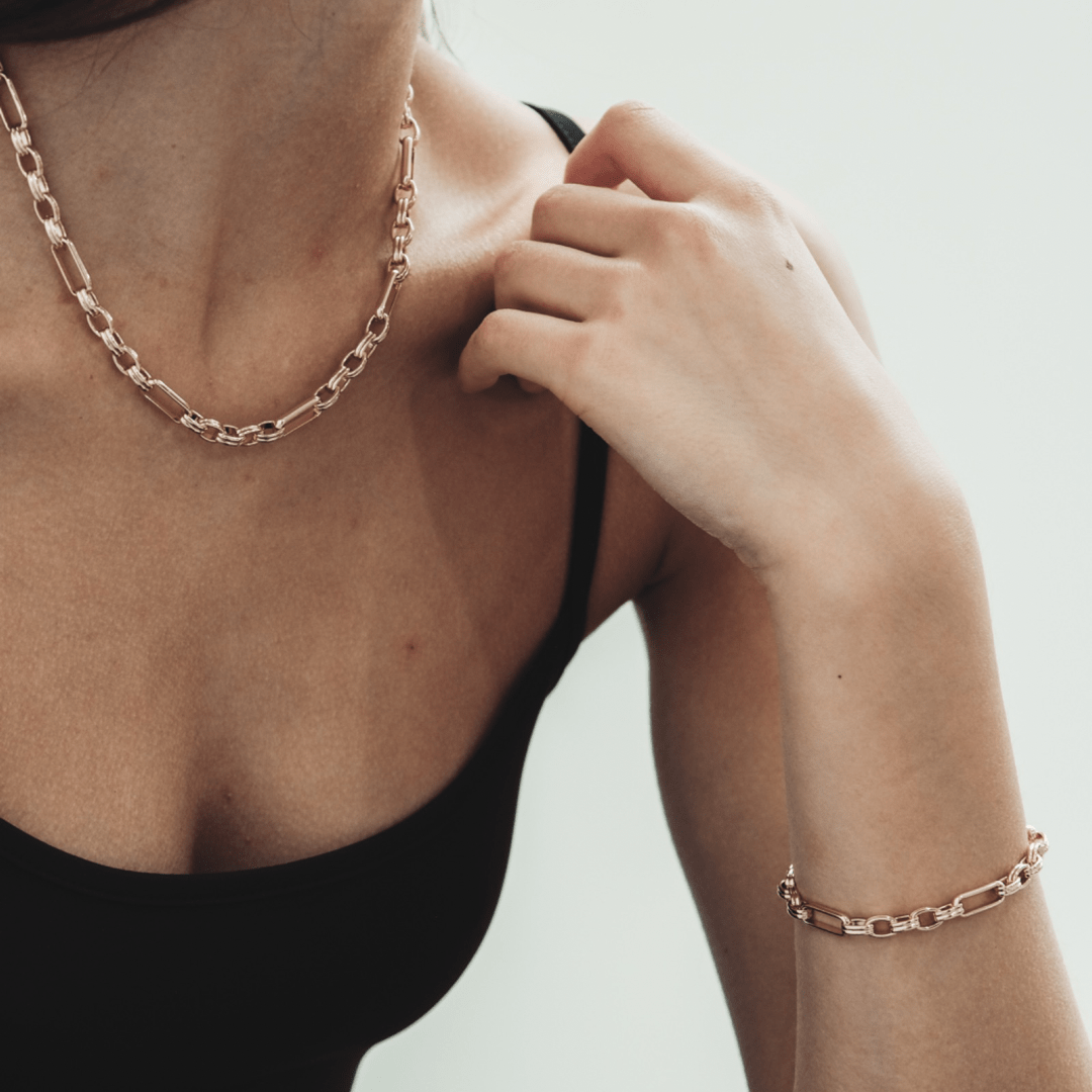 Woman wearing a rose-gold chain necklace and matching Triple Link Bracelet.
