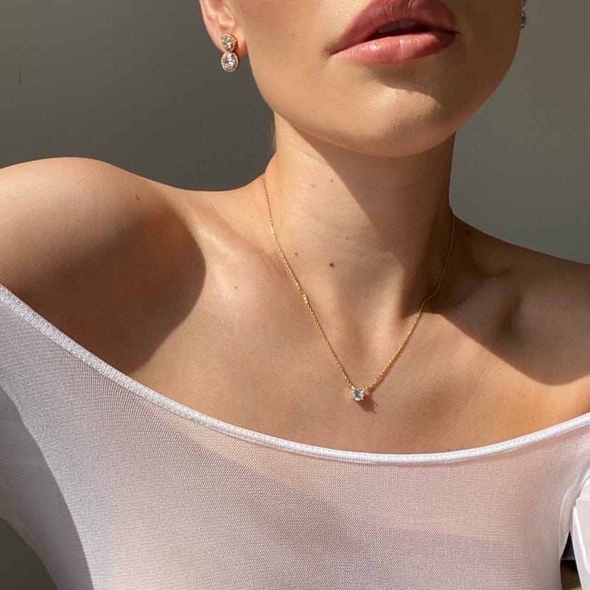 Close up of a person with jewelry wearing a white top, featuring the Bridal Floating Diamante Necklace.