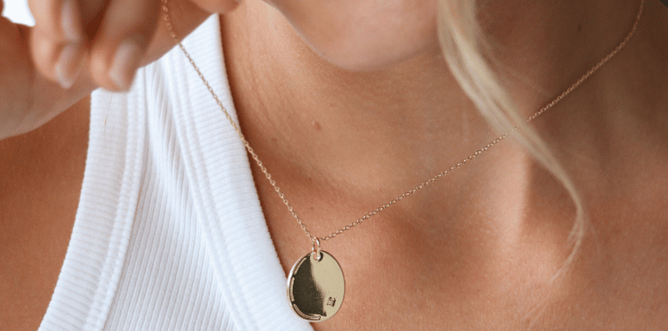 Close-up of a person wearing a delicate chain necklace with star charms.