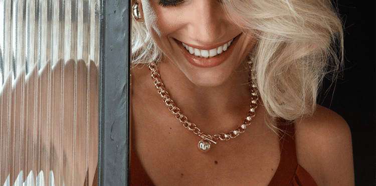 Close up of a person wearing gold chain jewelry.