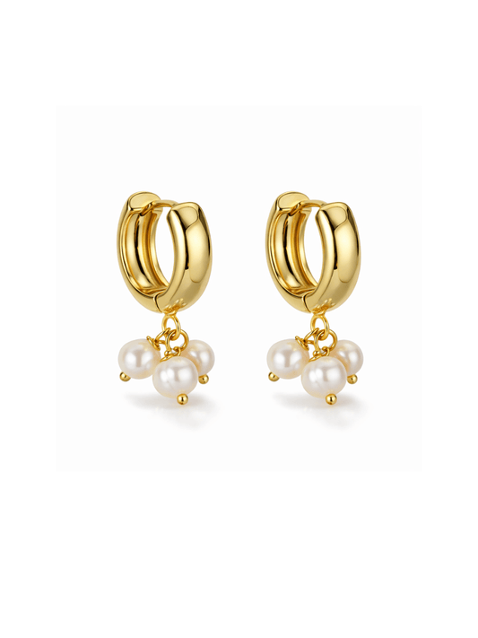 Gold hoop earrings with pearl charms on a white background