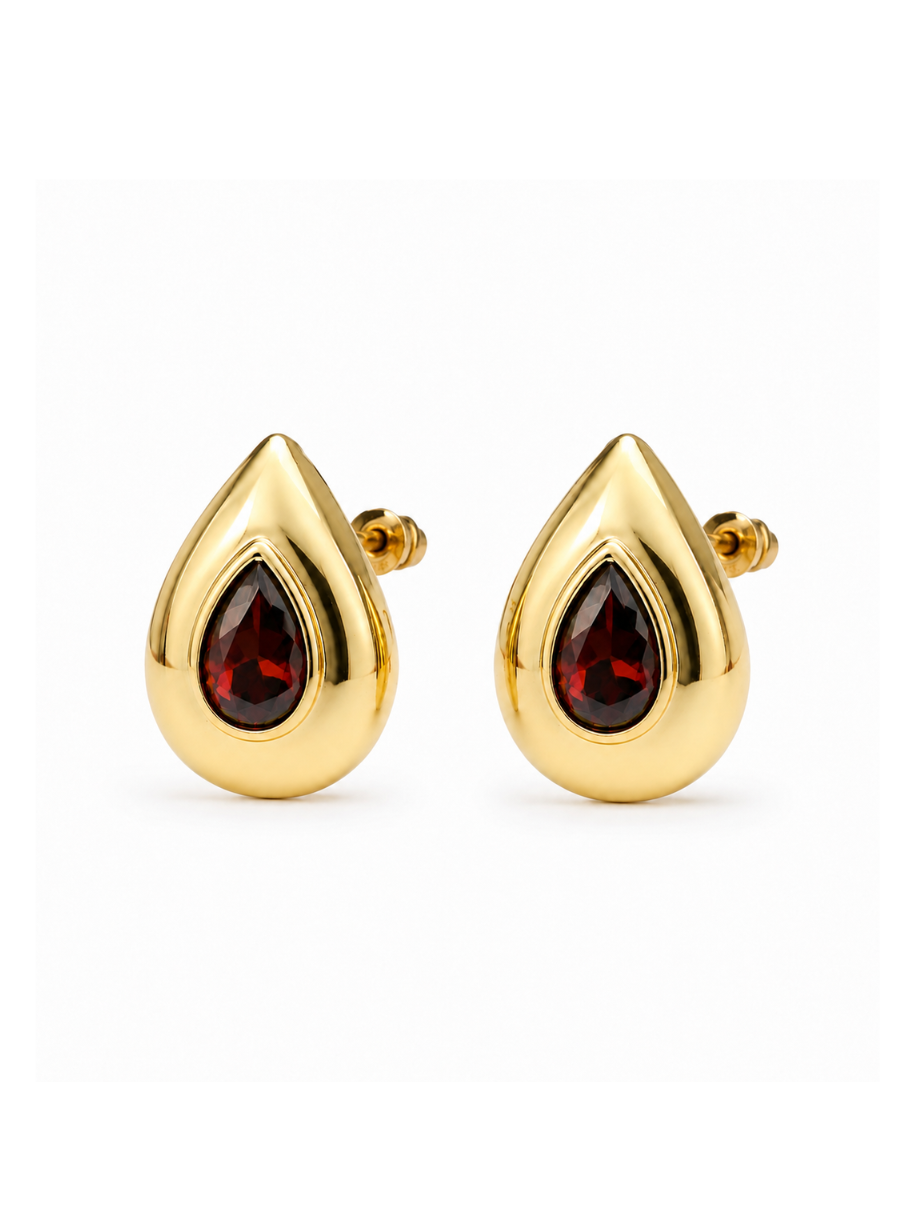 These Garnet Bezel Teardrop Earrings feature a deep red garnet stone set in a polished gold bezel. The teardrop shape gives them an elegant, elongated silhouette that catches the light.