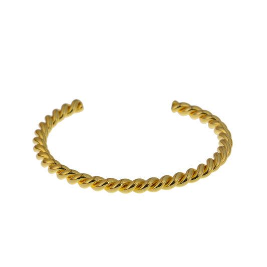 Gold-colored twisted metal bracelets on white.