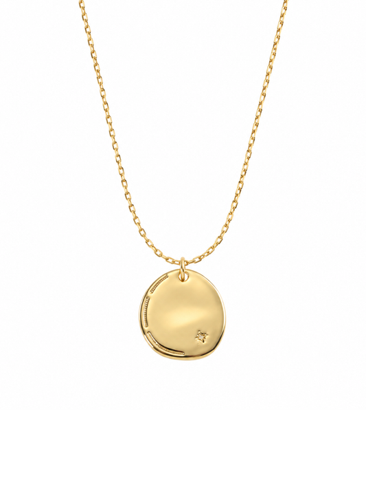 A gold disc pendant necklace on a delicate gold chain, presented against a solid white background.