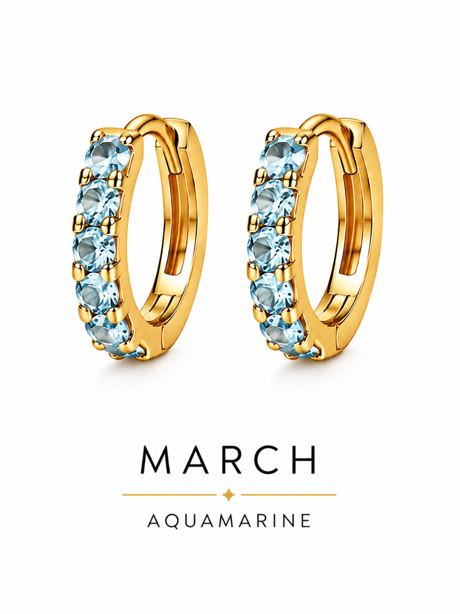 March birthstone gold huggie earrings featuring light blue aquamarine gemstones, birthstone jewellery