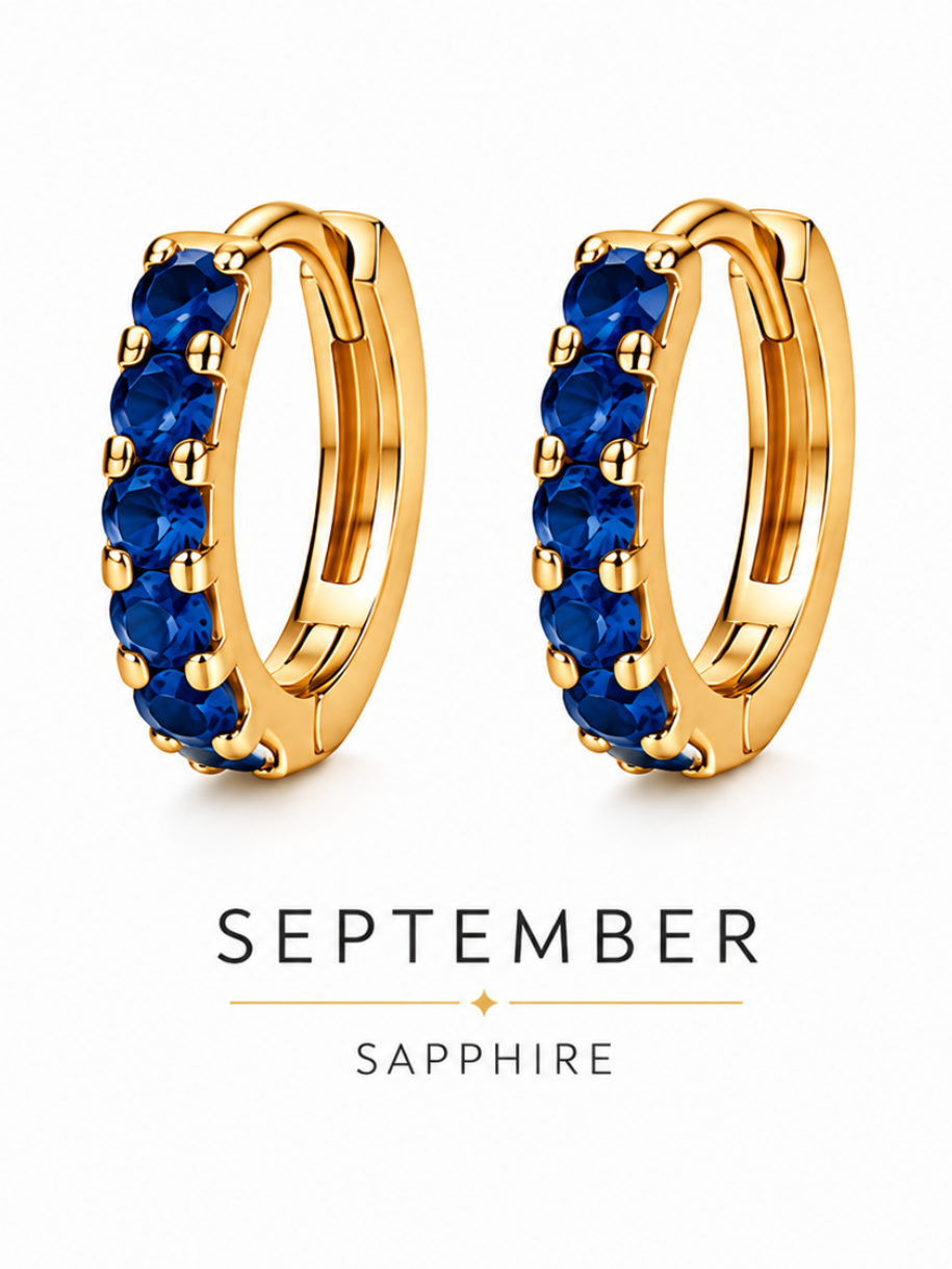 September birthstone gold huggie earrings featuring deep blue sapphire gemstones, birthstone jewellery