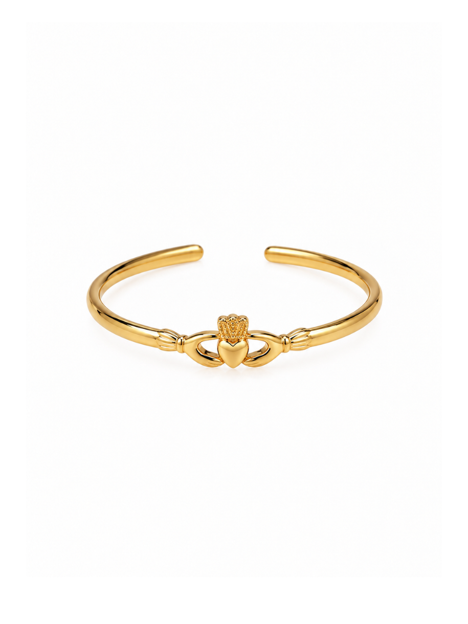 A polished gold-tone open cuff bracelet featuring a central Claddagh heart and hands motif, displayed on a clean white background.
