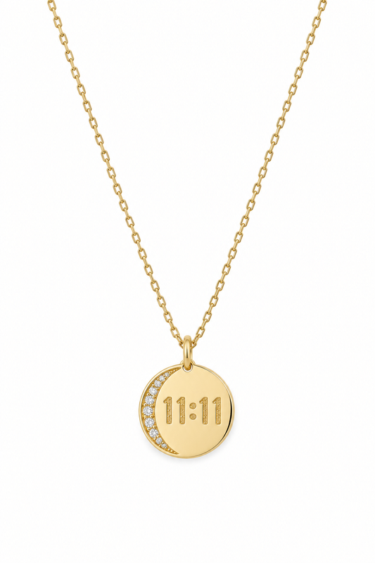 A gold chain necklace with a round pendant featuring a crescent moon and the time '11:11' in a square clock face design, set against a plain white background.