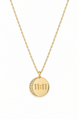 A gold chain necklace with a round pendant featuring a crescent moon and the time '11:11' in a square clock face design, set against a plain white background.