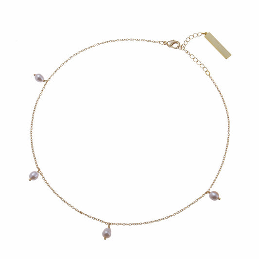 A snow drop pearl necklace on a delicate gold chain bracelet 